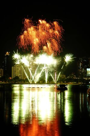 Beautiful colorful fireworks with night sky and lake reflectionsの写真素材