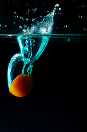 Tomato water splash on black backgroundの写真素材
