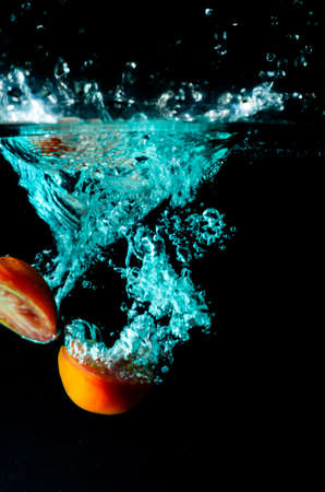 Tomato water splash on black backgroundの写真素材