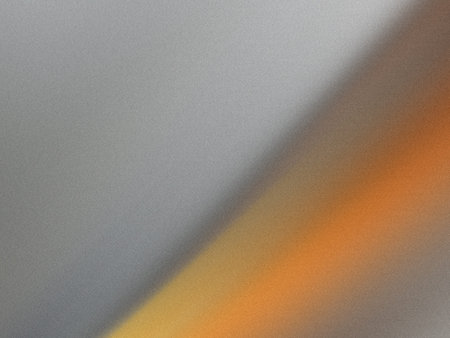 This image displays a textured gray and orange gradient background. The gradient transitions from gray on the left to orange on the right, with a white border at the bottom. The image has a rough texture, giving it a unique and artistic appearance.の写真素材