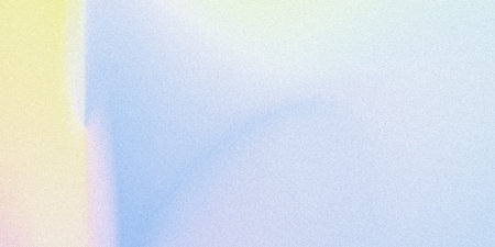 The image showcases a smooth gradient transitioning from a warm yellow hue on the left to a cooler, pale blue-gray on the right. The gradient is subtle and seamless, creating a soft and almost imperceptible blend that gives a minimalistic and serene aesthetic. The texture appears smooth with a faint, uniform graininess throughout the surface.の写真素材