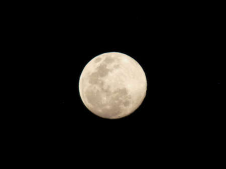 The yellow full moon on black background.の写真素材