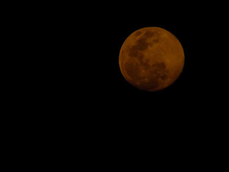 The yellow full moon on black background.の写真素材