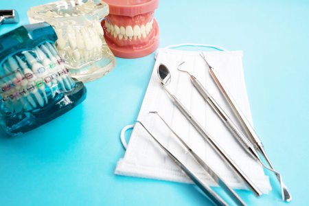 Dentist tools and orthodontic on color background, flat lay, top view.