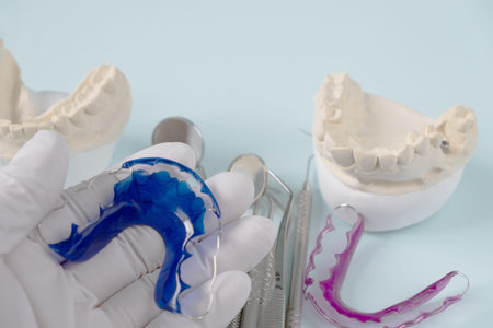 Dental  tools  and retainer orthodontic appliance on the blue background.