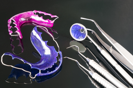Dental  tools  and retainer orthodontic appliance on the black background.の写真素材