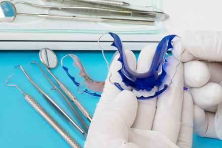 Dental  tools  and retainer orthodontic appliance on the blue background.の写真素材