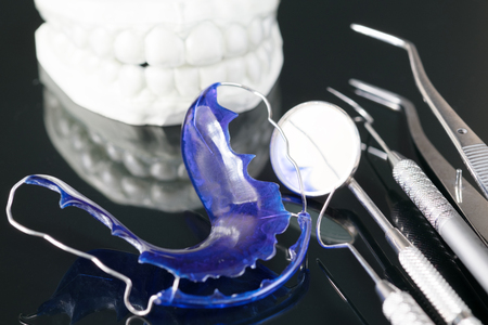 Dental  tools  and retainer orthodontic appliance on the black background.の写真素材
