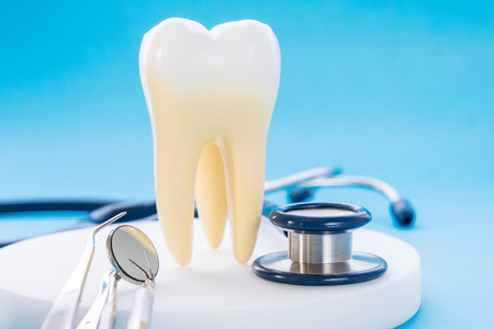 close up tooth and stethoscpe, dental equipment on the blue backgroundの写真素材
