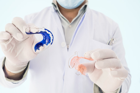 Dentist show dental retainer orthodontic appliance on his hand.の写真素材