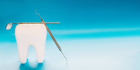 Big tooth and dentist tool on blue background.の写真素材