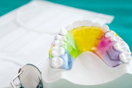 Dental retainer orthodontic appliance and dental tools on the colour background.の写真素材