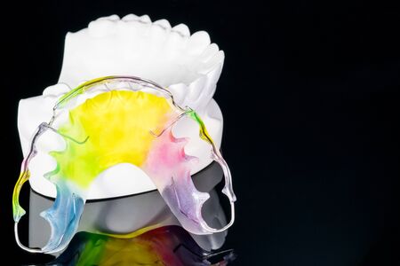 Close up Dental retainer orthodontic appliance and dental tools on the black background.の写真素材
