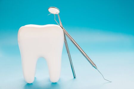Big tooth and dentist tool on blue background.の写真素材