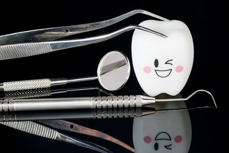 Close up; Dental tools and smile teeth model on black background.の写真素材