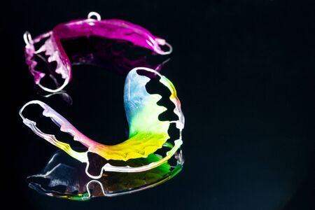 Close up; Dental retainer orthodontic appliance and dental tools on the black background.の写真素材