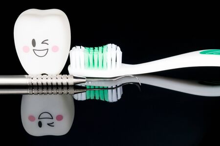 Close up; Dental tools and smile teeth model on black background.の写真素材