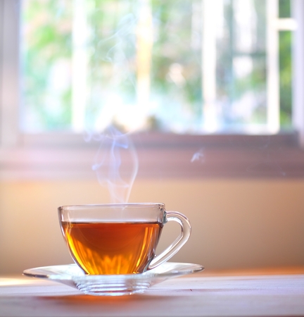 Hot tea on wood table and window backgroundの写真素材