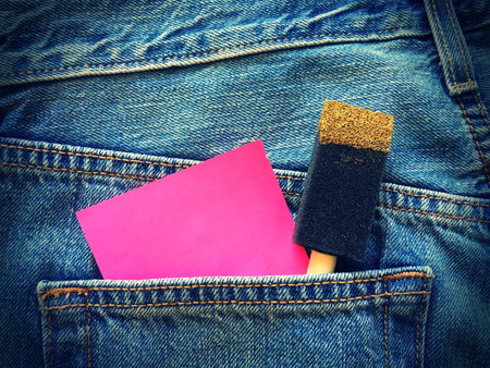 pink sticky note with Foam Paint Brush in the pocket of blue denim jeans retro style