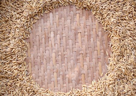 Paddy Jasmine rice on weave basket background with copy spaceの写真素材