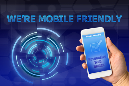 Woman hand holding smartphone against digital blue background MOBILE FRIENDLY conceptの写真素材