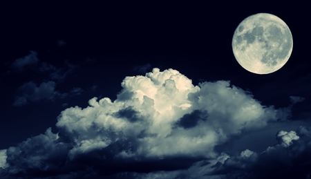 Night sky and a full moon in the cloudsの写真素材
