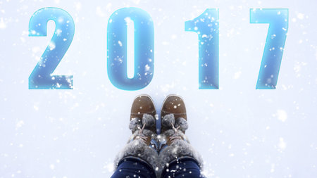 woman boots standing in the snow, top view with word 2017の写真素材