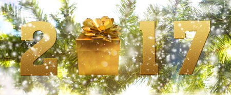 blurred of christmas background with fir tree and snow effect with word 2017 and gift boxの写真素材