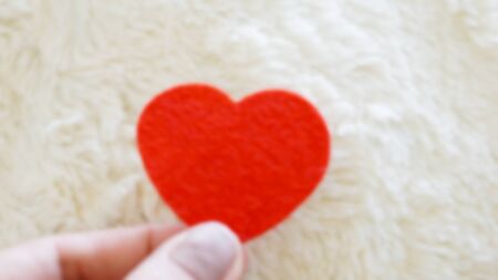 holding red heart blurred background with copy spaceの写真素材