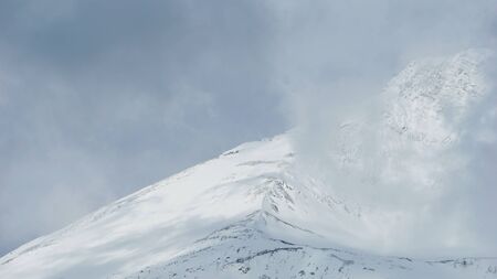 top of mountain covered with snow in National Park same level as cloudの写真素材