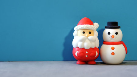 Santa Claus and snowman decorated on a turquoise background, with space to insert text.の写真素材