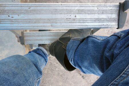 Close-up Of Man climbing up on Steel Ladderの写真素材