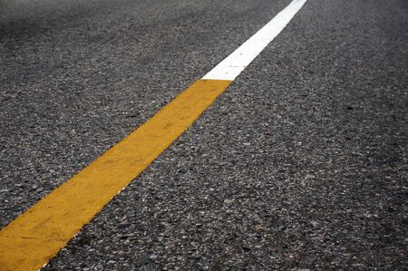 Yellow paint on white solid line road marking background and abstract.の写真素材