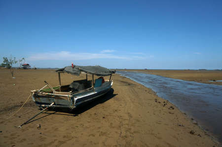Teluk lombok beach when recede at  Sangatta, East Kalimantan/Indonesia. Object wooden fishing boat.の写真素材