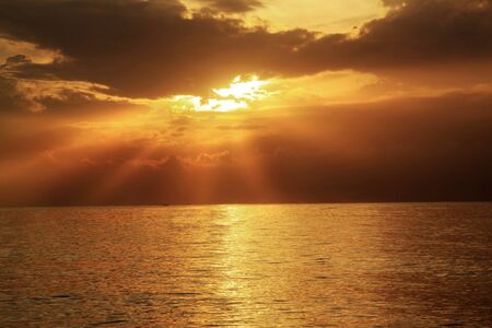 Beautiful Sunrise with rays of Light at seaの写真素材
