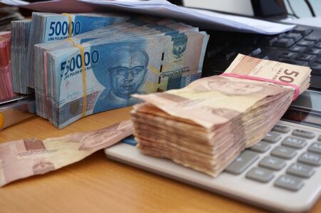 Sangatta, East Kalimantan/Indonesia-10 March 2020: Money indonesian Rupiah Bank notes,                        Indonesian Currency.  Money Indonesian rupiah on work desk in the officeの写真素材