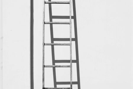 Alumunium ladder on white concrete wall backgroundの写真素材