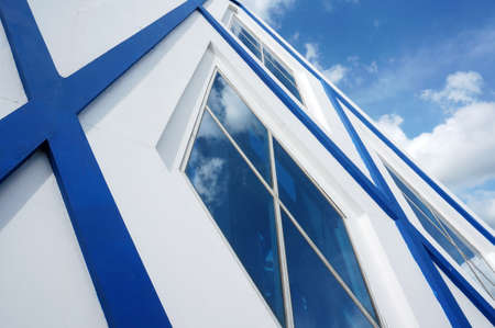 Sangatta, East Kutai, East Kalimantan/Indonesia - 06 August 2020: Blue and white modern architecture with Pentagon glass windows. Blue sky and cloud reflection.のeditorial素材