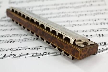 A harmonica on music sheets backgroundの写真素材