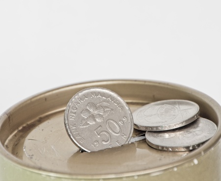 Gradual accumulation of coins into an old metal boxの写真素材