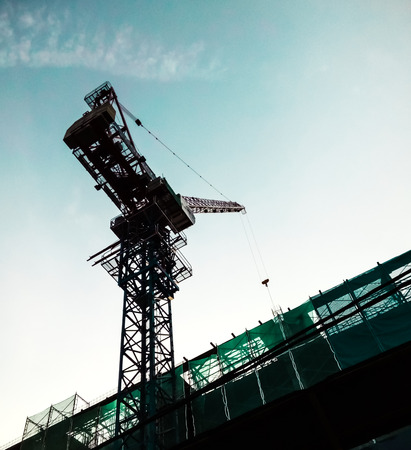 Tower crane idling, awaiting instruction before proceed.の写真素材