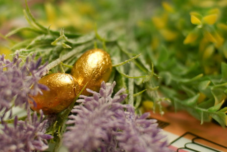 golden easter egg wrapped with golden foil - chocolate eggs with flower background