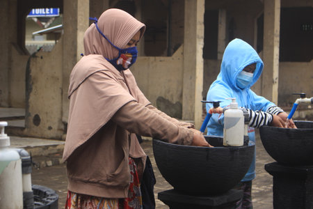 Dieng, Indonesia - 29 December 2020: Covid-19 virus prevention protocol. Tourists are cleaning their hands before traveling to Dieng tourism objects to prevent the Covid-19 virusのeditorial素材