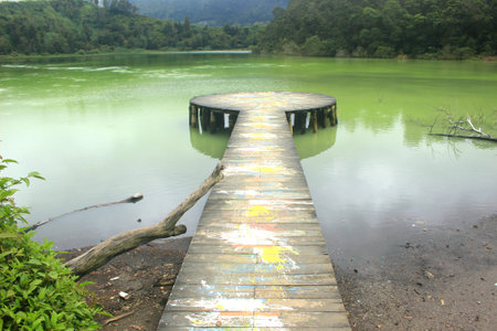 wooden pier for photo spots at Telaga Warna tourism object. Dieng, Indonesiaの写真素材