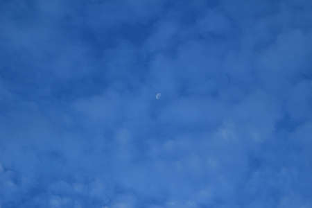 moon in a beautiful cloudy blue skyの写真素材