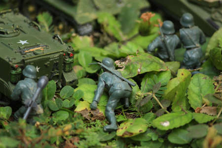 Miniature infantry and tank cavalry are being stationed in the forest. Jungle battlefield camouflaged with army uniform.の写真素材