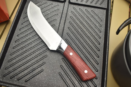 Kitchen knife on a black cutting board with a red handle.の写真素材