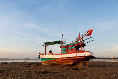 The fishing boat on the beach in sunset