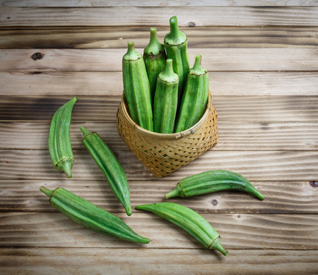 Fresh okra in a basket on the  wood backgroundの写真素材