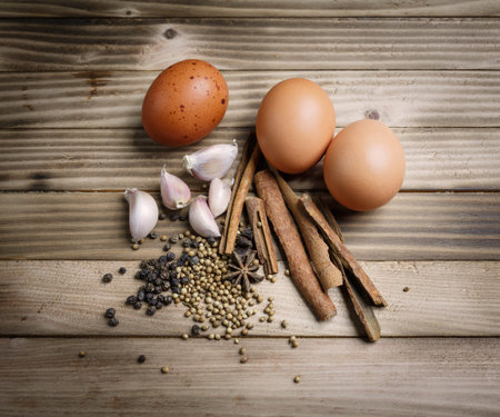 Herbs and spices stewed eggs on the wood background
